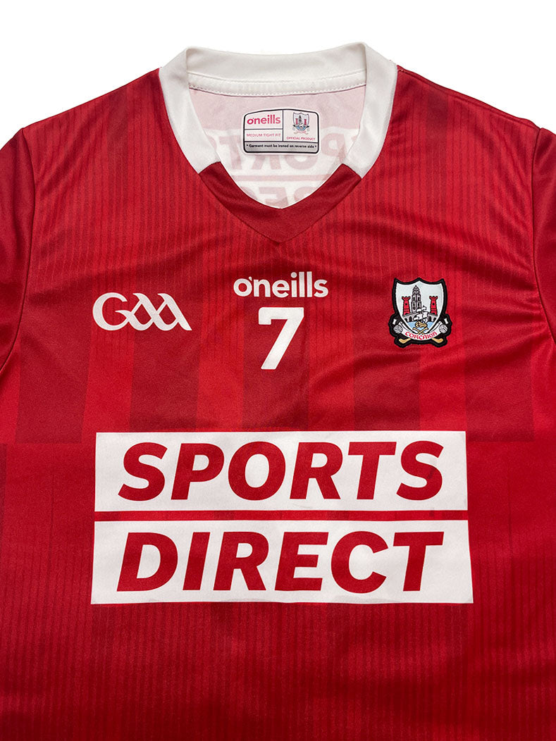 Red sports jersey with branding and logos on a white background