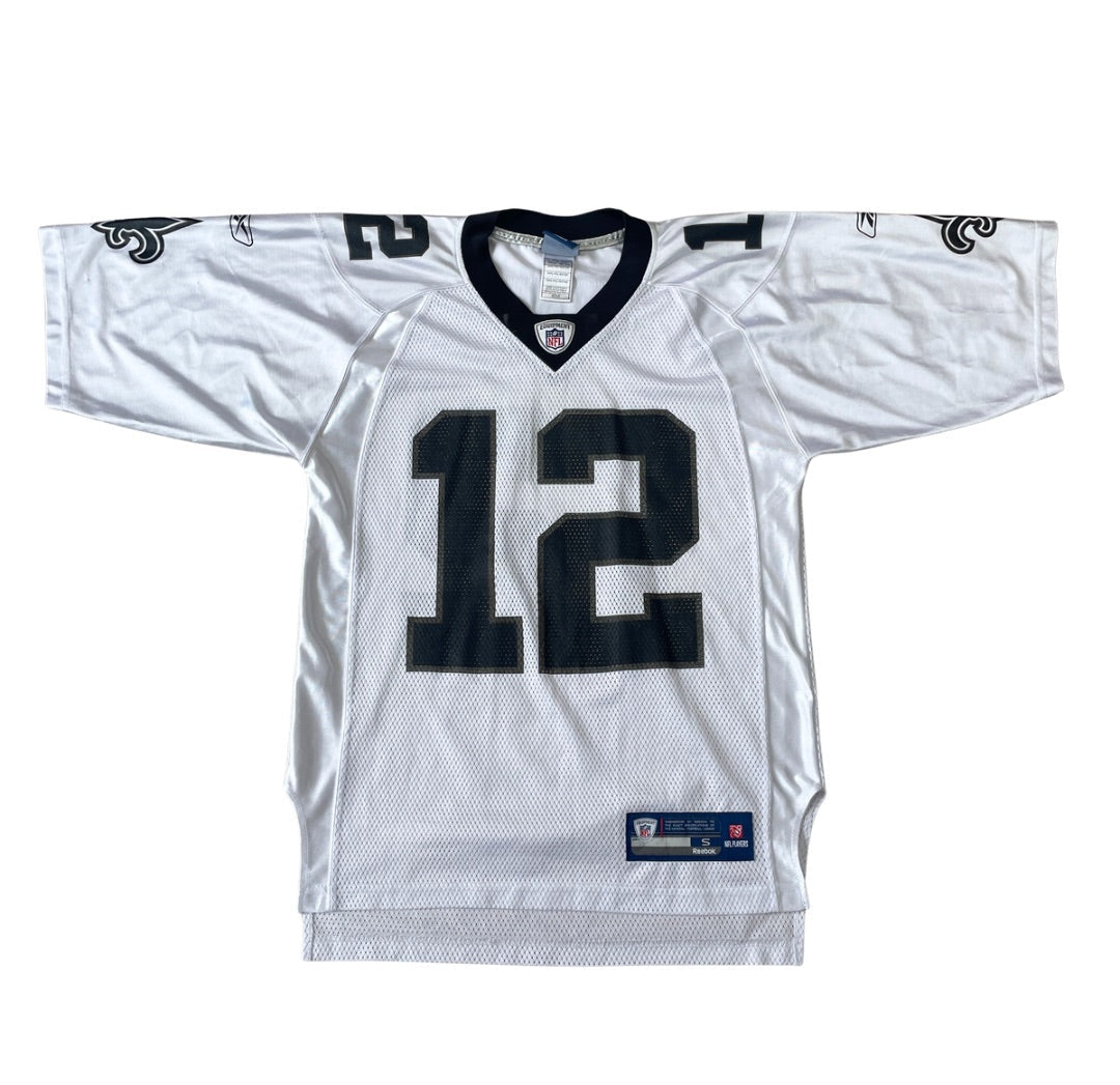 A white New Orleans Saints football jersey with the number 12 on the front, featuring black and white detailing, laid flat against a white background.