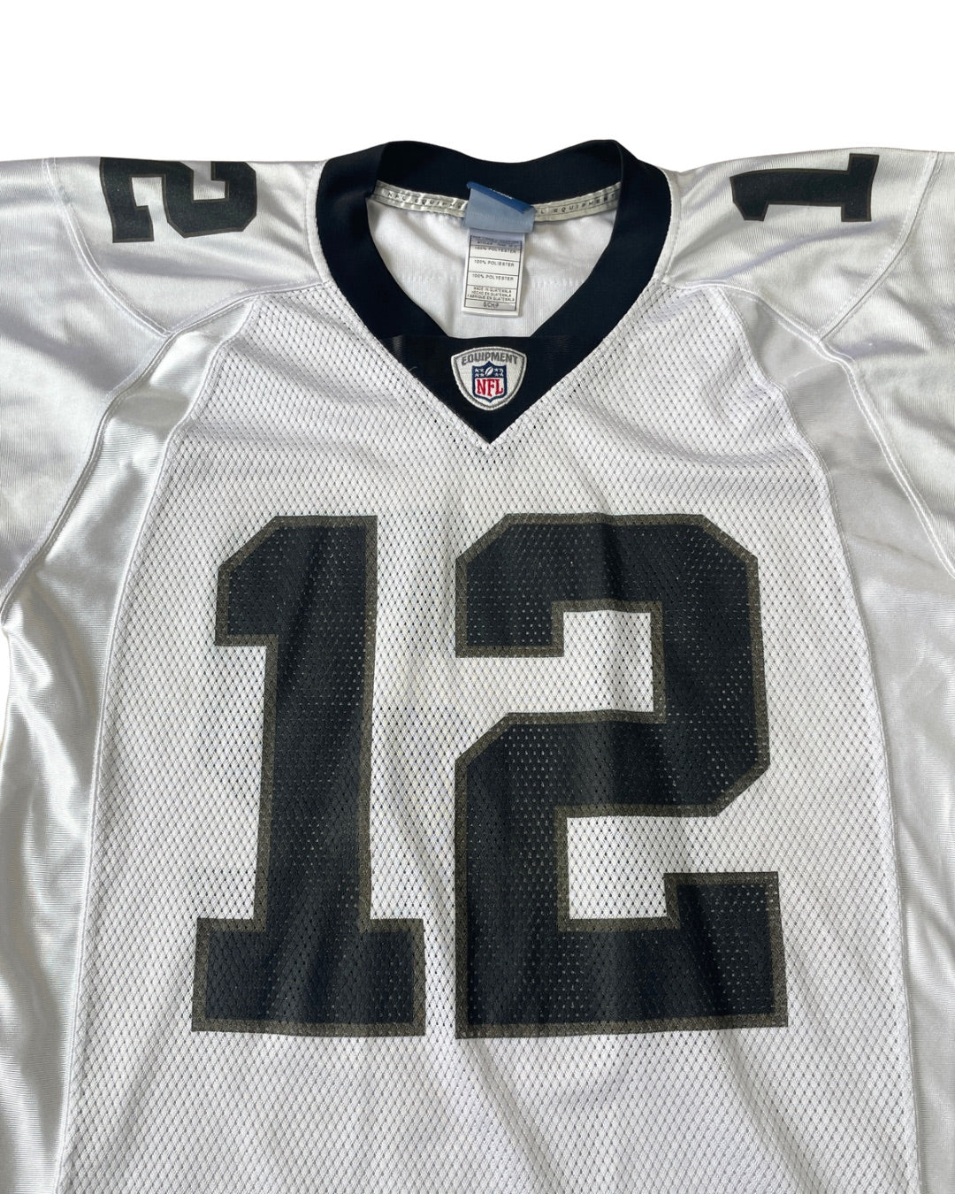 A white Dallas Cowboys football jersey with the number 12 on the front, featuring a navy blue V-neck collar and NFL shield logo.