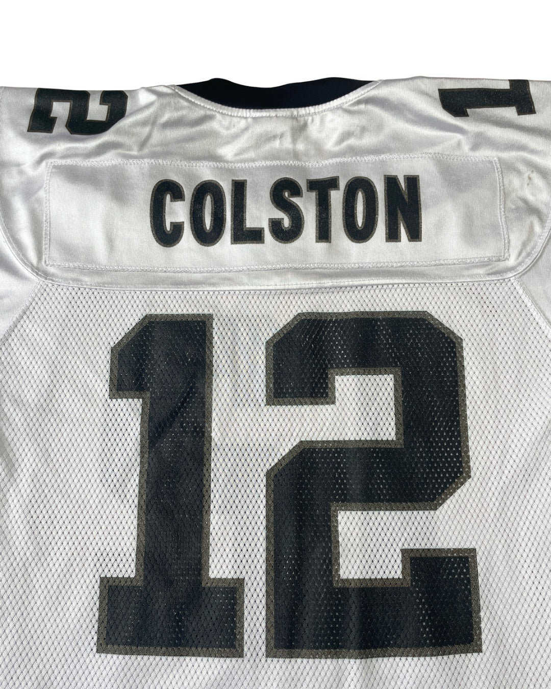 Close-up of the back of a white football jersey with 'COLSTON' and the number '12' in black on a white mesh back panel.